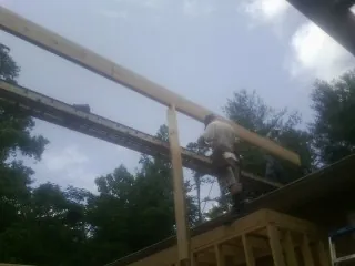 Carpenter setting a ridge beam over a new addition frame — Ice Dam Removal by Roofing Brothers in Sayville