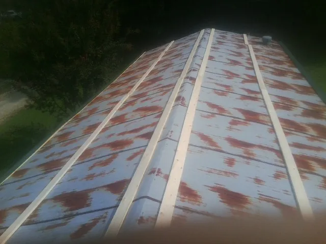 Rusted metal roof panels with new wood purlins before replacement — Storm Damage Roof Repair in Sayville by Roofing Brothers