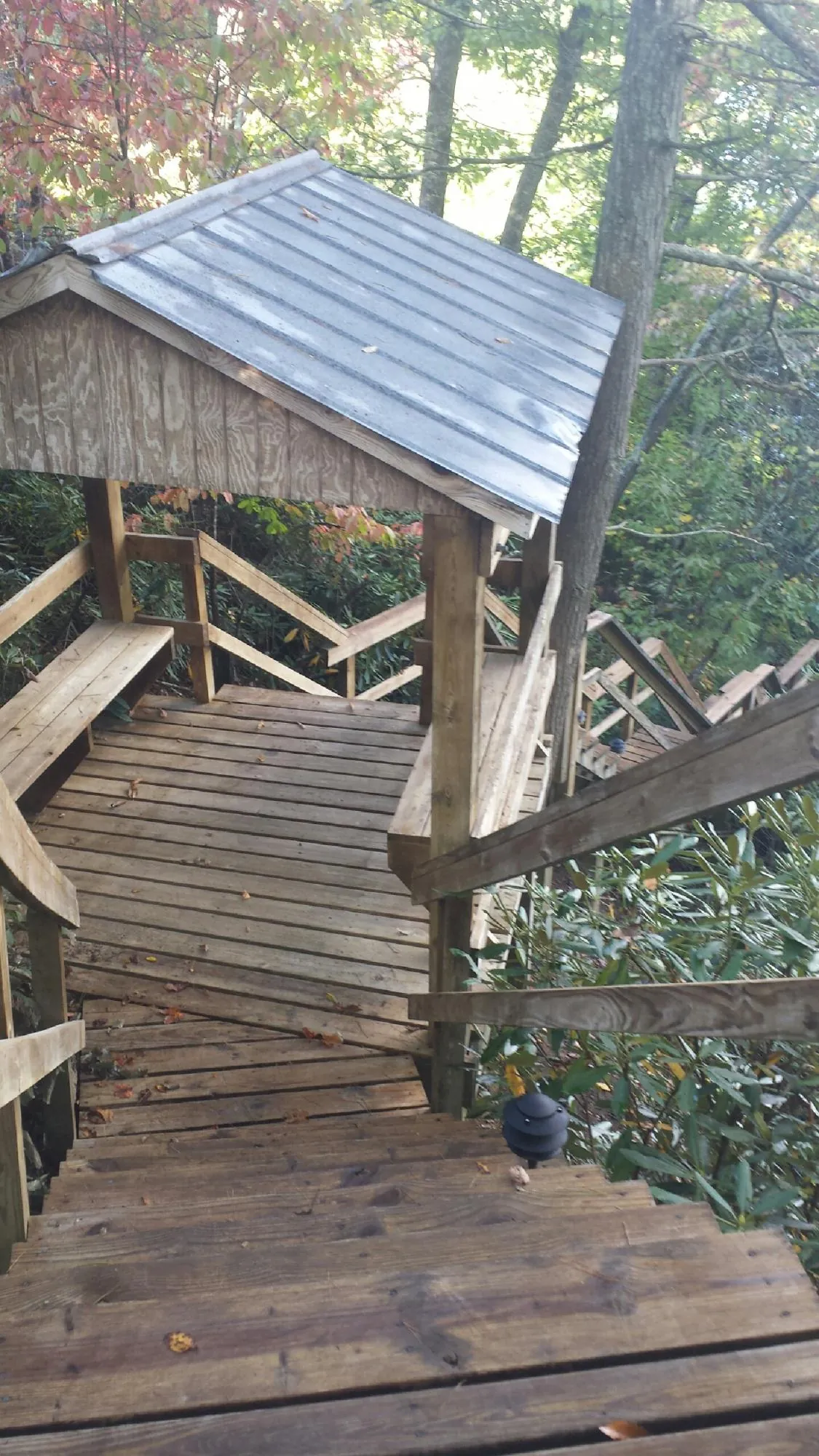 Metal roofed shelter over wooden steps on a wooded walkway — Skylight Repair & Installation work by our crew in Sayville