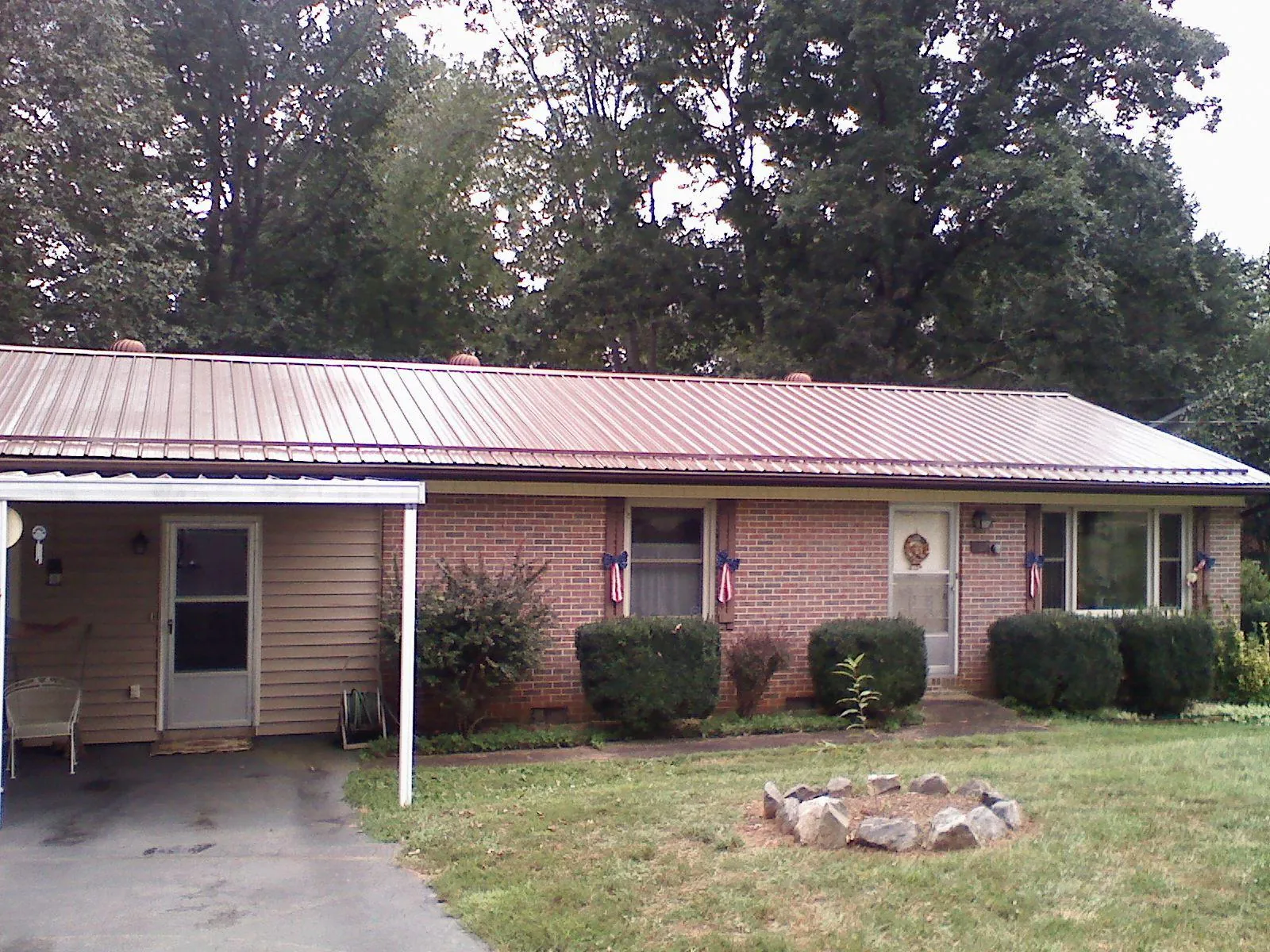 Bronze metal roof and carport on a brick ranch home — Roof Repair work by our crew in Sayville